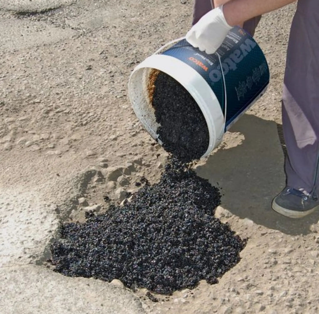 Person pouring black Bitu-Mend from a container onto a concrete surface.