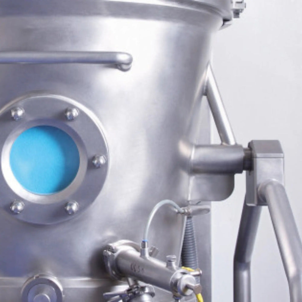 Close-up of a metallic industrial component with a blue valve on a light gray background