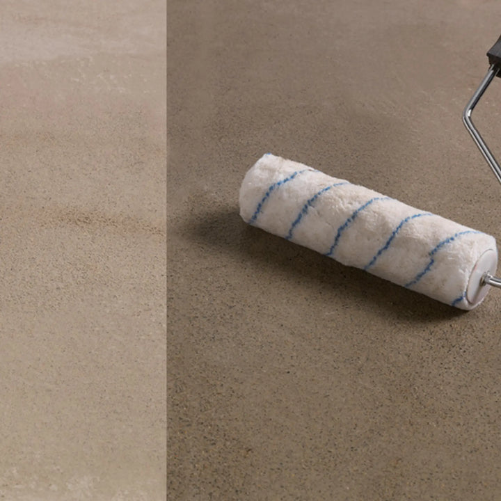 Paint roller with blue stripes on a beige surface