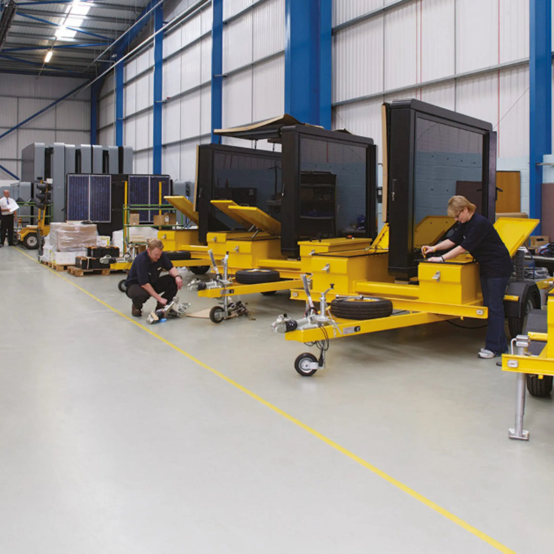 Yellow industrial trailers in a warehouse setting with workers.