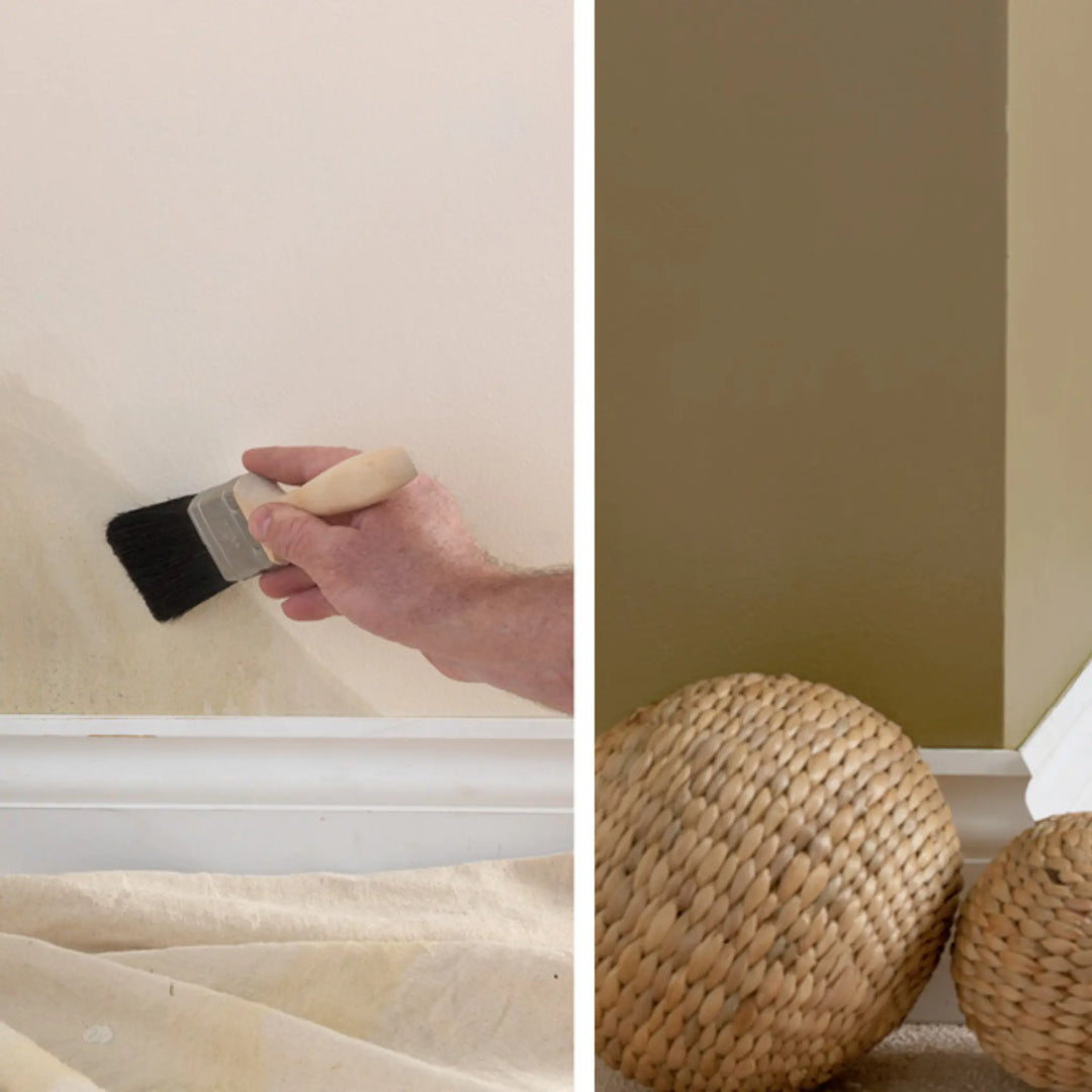 Person painting a wall with a brush and two woven balls on the floor.