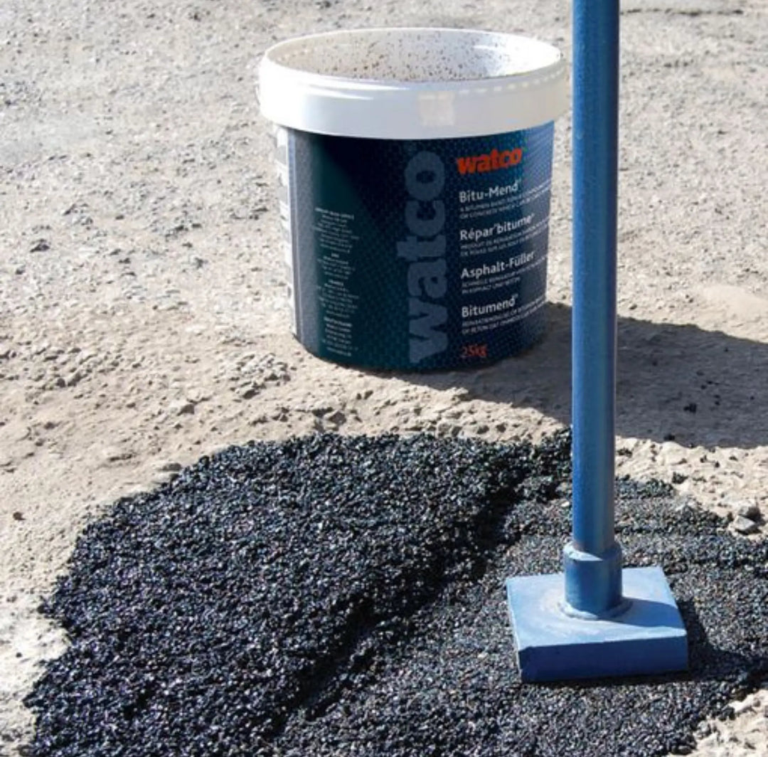 Bucket of Walco asphalt repair material on a patch of asphalt