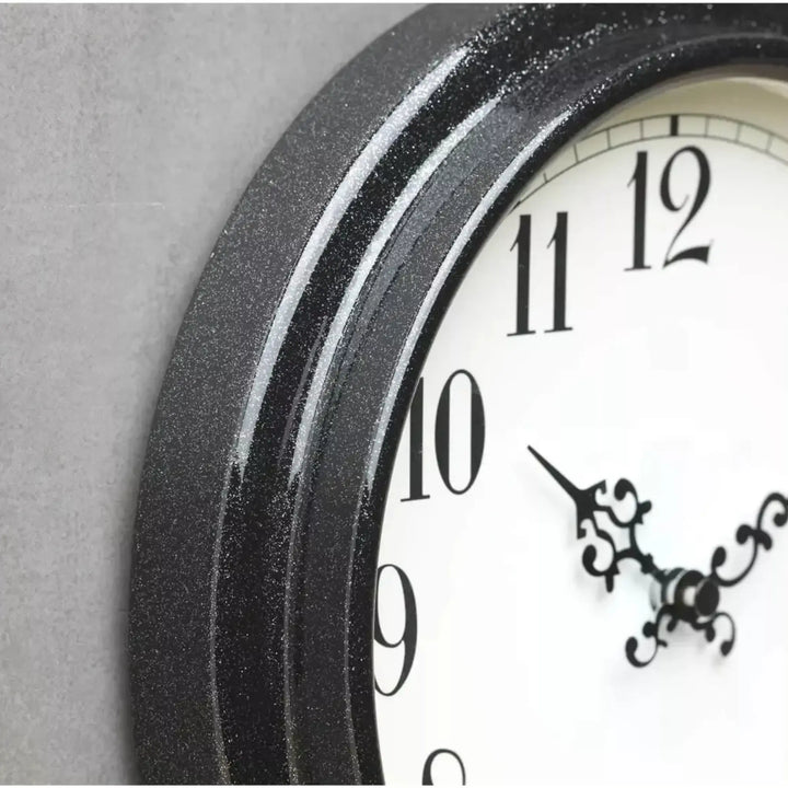 Wall clock with black frame and white face on a gray background