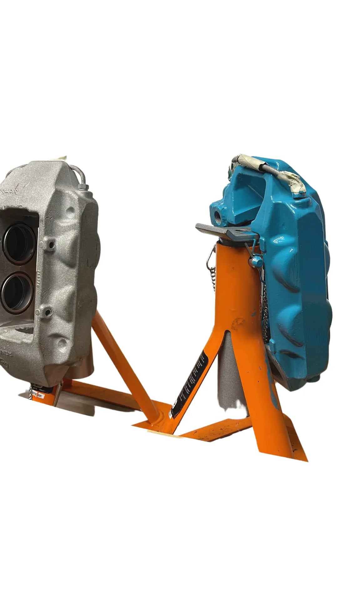 Two mechanical components on an orange stand against a white background