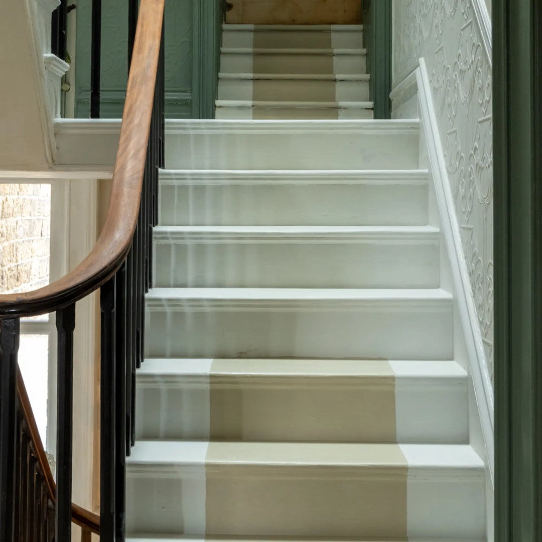 White staircase with a checkered runner in a home setting