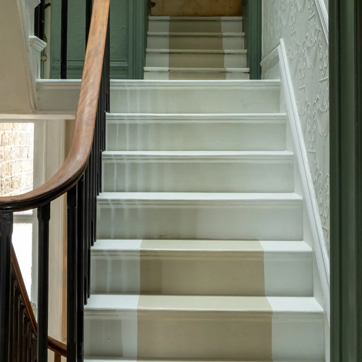 White staircase with a checkered runner in a home setting
